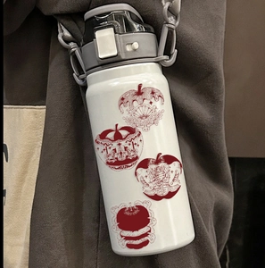 Insulated stainless steel water bottle with red apple illustration and shoulder strap