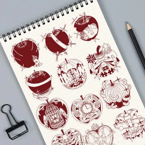 Detail of red vintage apple stickers with clock and skull motifs on a spiral notebook
