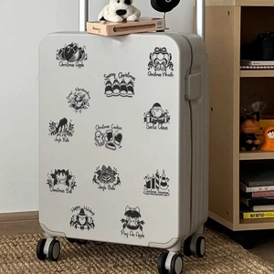 Gros plan d'autocollants de Noël monochromes noir et blanc sur une valise blanche