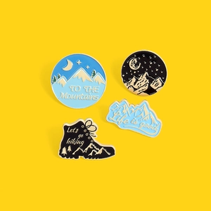 Detailed close-up of mountain hiking pins set with enamel finish and gold borders