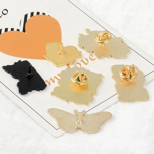 Detailed view of enamel pins showing metal butterfly clutch backings and alloy texture