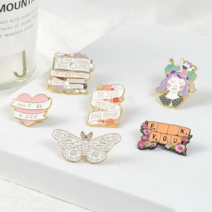 Artistic collection of enamel lapel pins with heart, books, and floral girl illustrations