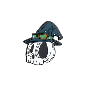 Detail of Halloween enamel pin with skull wearing a blue wizard hat on white background