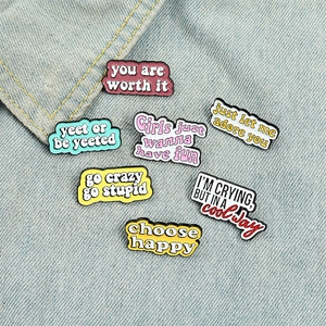 Broches en émail coloré avec messages inspirants sur un fond de tissu en jean bleu