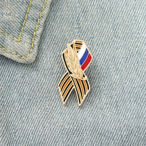 Broche ruban en émail avec épis de blé et drapeau sur fond en denim