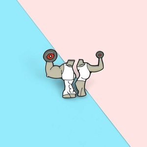Detail view of fitness couple enamel pins featuring weightlifting figures on pastel background