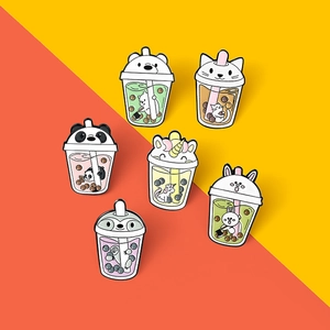 Close-up of six cartoon animal bubble tea enamel pins on vibrant orange and yellow background