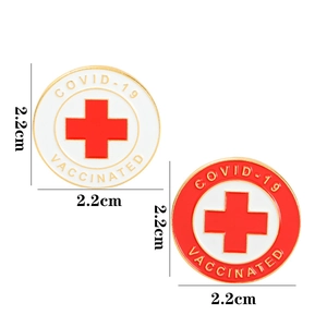 Detail view of two 2.2cm COVID-19 Vaccinated enamel medical badges in red and white colors