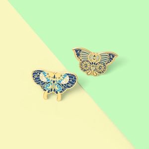 Detailed macro view of vintage butterfly enamel brooches with celestial moon and star motifs