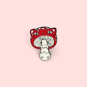 Broche en émail chat champignon rouge avec visage mignon sur un fond rose pastel