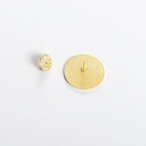 Detailed back view of gold round medical brooch with butterfly clasp and textured finish