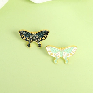 Detail of colorful enamel butterfly brooches with crescent moon and star patterns