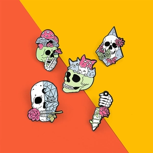 Set of gothic enamel skull pins with floral and mushroom motifs on vibrant background