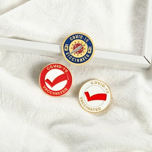 Three-piece COVID-19 Vaccinated enamel pin set with medical symbols on a white background