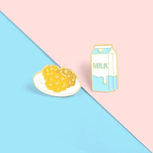 Detail van schattige emaille pinnen set met melkpak en koekjes op kleurrijke achtergrond