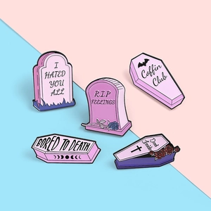 Detailed close-up of 5 Gothic enamel pins featuring pink coffins and tombstones