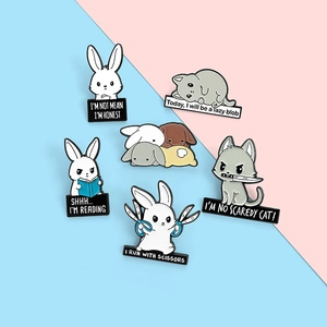 Close-up of cute cartoon enamel animal pins with rabbits and cats on blue pink background