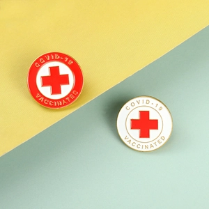 Detailed close-up of two enamel medical pins with COVID-19 Vaccinated text and red cross