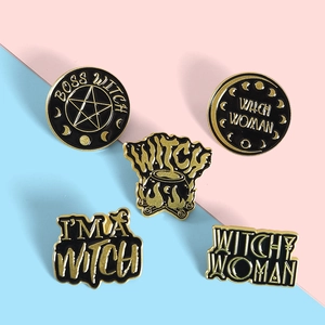 Macro detail of five black enamel witch badges with gold plating and star motifs