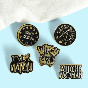 Detailed view of vintage black and gold enamel witch theme pins on blue background