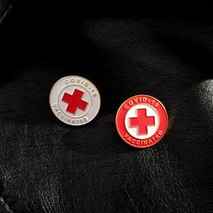 Detailed macro shot of circular enamel COVID-19 Vaccinated badges on black leather