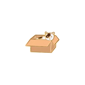 Macro detail of cartoon white cat in cardboard box enamel pin crafted from metal