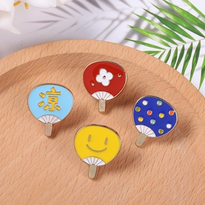 Lot de quatre broches en émail en forme d'éventail d'été sur un plateau en bois