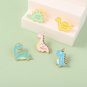 Set mit fünf bunten Cartoon-Dinosaurier-Emaille-Anstecknadeln in Pastellfarben