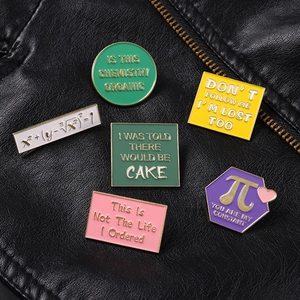Detailed close-up of six creative enamel pins with math and science motifs on leather