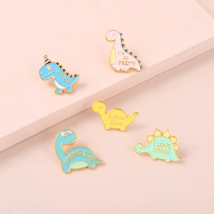 Details von fünf bunten Dinosaurier-Emaille-Pins mit goldenen Metallkanten im Set