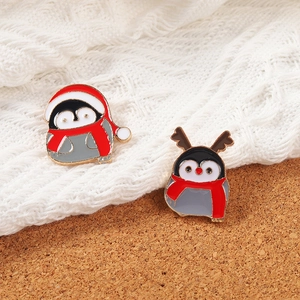 Cute Christmas penguin enamel pins with red hats and scarves on knitted fabric