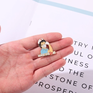 Golden enamel nurse brooch with Nurse Strong text in a powerful We Can Do It pose