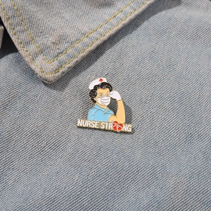 Detail of Nurse Strong enamel pin with stethoscope on denim fabric background