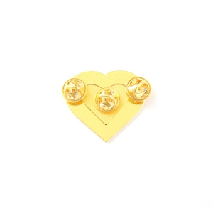 Detail view showing three butterfly clutches on the back of a gold heart metal badge