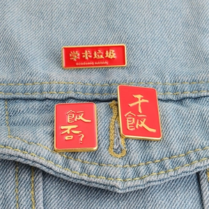 Detail of red enamel creative pins with gold trim on light blue denim jacket