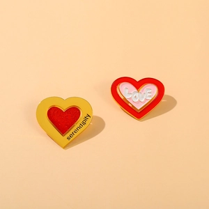 Detail of heart enamel pins with serendipity engraving and white 3D love lettering