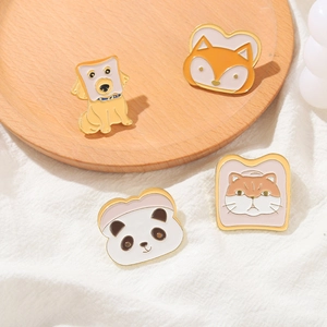 Détail de broches en émail animaux et toasts avec panda et renard sur plateau bois