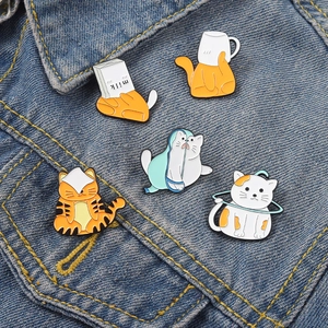 Détail de badges en émail de chats mignons sur une texture de tissu en denim bleu