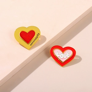 Detail view of enamel heart brooches with serendipity and love lettering