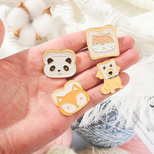 Gros plan de pins en émail mignons avec motifs panda et renard toast en main