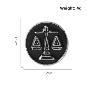 Detail view of round black enamel Libra scale pin measuring 1.2cm in diameter and weighing 4g
