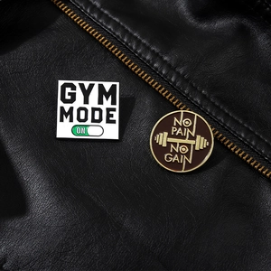 Detail of Gym Mode and No Pain No Gain enamel pins on a black leather jacket texture