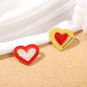 Pink heart enamel pins set with LOVE and serendipity text on beige sand background