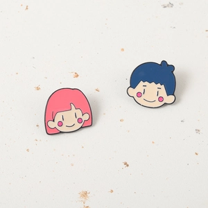 Détail de pin's émaillés fille rose et garçon bleu avec finition en métal poli