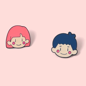 Gros plan de pin's émaillés couple mignon avec figurines fille rose et garçon bleu