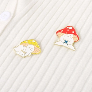Détail de pin's champignons en émail sur un tissu en maille côtelée blanche avec bouton