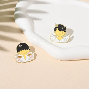 Artistic enamel pins featuring cartoon figures on a decorative display tray in soft light
