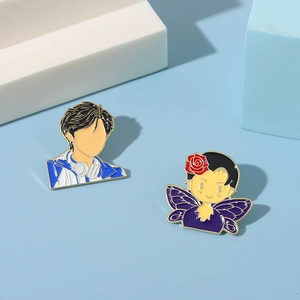 Detailed macro view of enamel pins featuring boy and girl anime characters on blue base