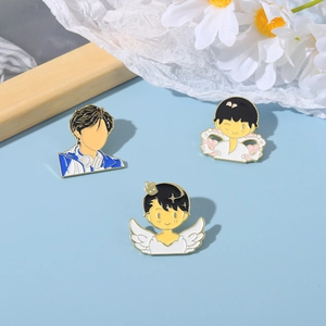 Detailed close-up of cute cartoon enamel pins with crown and wings on a blue background