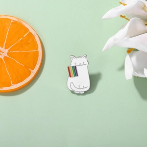 Detail of a cute white cat enamel pin holding a rainbow flag on a fresh floral background